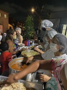 Garçonete bonita servindo grupo de amigas com comida no restaurante